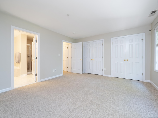570 Danbury Rd Unit 14, Ridgefield, CT 06877 - unfurnished bedroom featuring two closets, light colored carpet, and ensuite bathroom