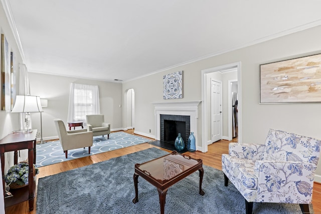 29 Boswell Rd, West Hartford, CT 06107 - living room with wood finished floors, ornamental molding, arched walkways, and a brick fireplace