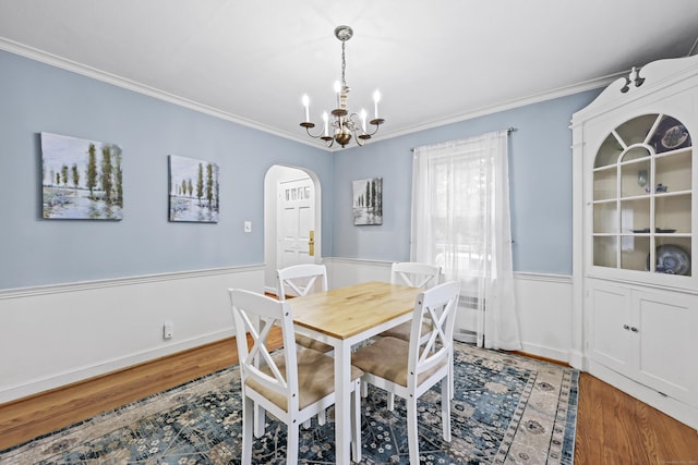 29 Boswell Rd, West Hartford, CT 06107 - dining space with arched walkways, ornamental molding, wood finished floors, wainscoting, and a chandelier