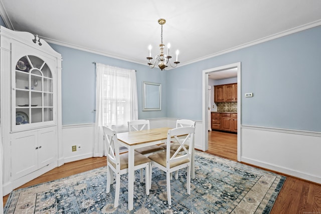 29 Boswell Rd, West Hartford, CT 06107 - dining area featuring a chandelier, light wood-style flooring, ornamental molding, and wainscoting