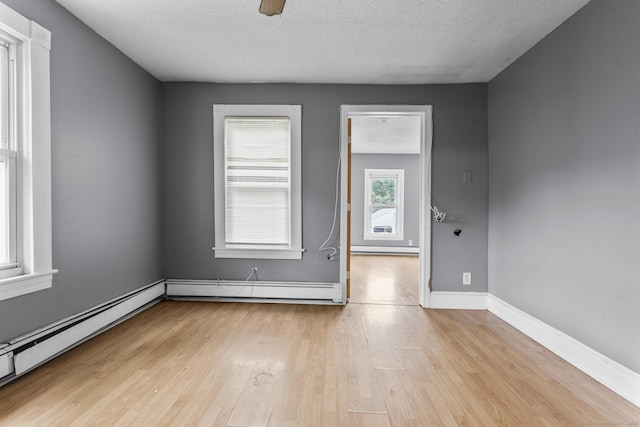 104 Greenwood St, New Britain, CT 06051 - empty room featuring wood finished floors, baseboard heating, a baseboard heating unit, a textured ceiling, and a ceiling fan