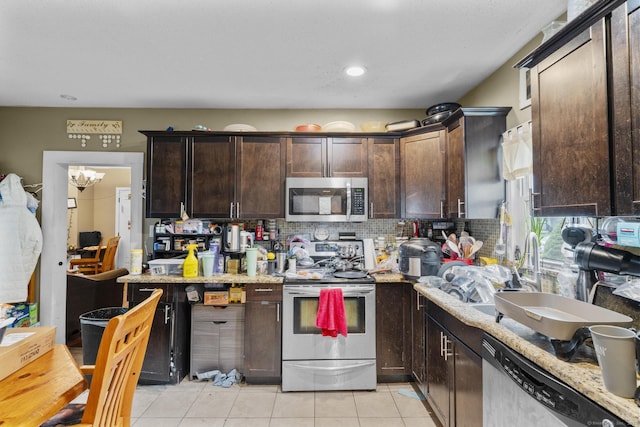 104 Greenwood St, New Britain, CT 06051 - kitchen with stainless steel appliances, dark brown cabinetry, backsplash, light tile patterned flooring, and recessed lighting