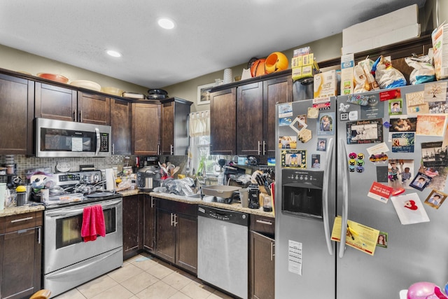 104 Greenwood St, New Britain, CT 06051 - kitchen featuring stainless steel appliances, dark brown cabinets, light tile patterned floors, decorative backsplash, and recessed lighting