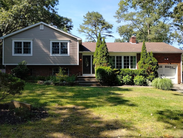 34 Taft St, Killingly, CT 06239 - split level home featuring an attached garage, brick siding, a front lawn, and a chimney