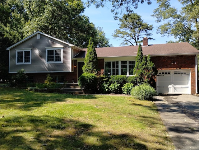 34 Taft St, Killingly, CT 06239 - split level home featuring brick siding, driveway, a chimney, an attached garage, and a front yard