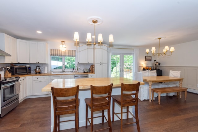 34 Taft St, Killingly, CT 06239 - kitchen featuring stainless steel appliances, wooden counters, a chandelier, healthy amount of natural light, and wainscoting
