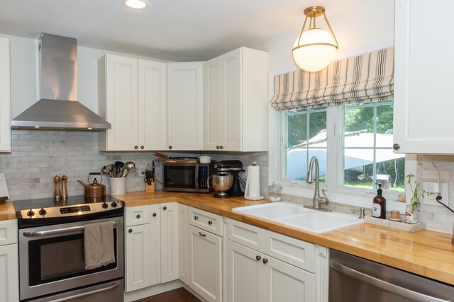 34 Taft St, Killingly, CT 06239 - kitchen featuring wall chimney exhaust hood, wood counters, appliances with stainless steel finishes, backsplash, and white cabinets