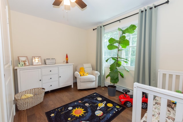 34 Taft St, Killingly, CT 06239 - bedroom featuring dark wood finished floors, a baseboard heating unit, a crib, and ceiling fan