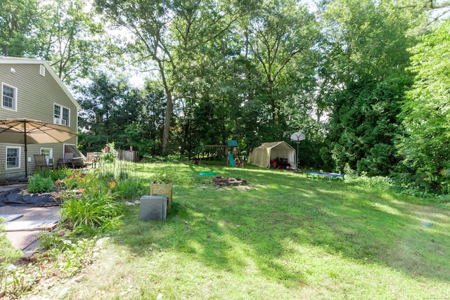 34 Taft St, Killingly, CT 06239 - view of grassy yard with a storage unit, a playground, and view of wooded area