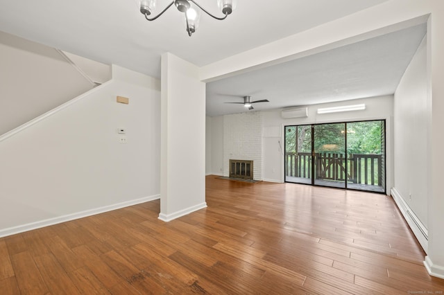 11 Danforth Ln Unit 11, Rocky Hill, CT 06067 - unfurnished living room with baseboard heating, an AC wall unit, a chandelier, wood finished floors, and a brick fireplace
