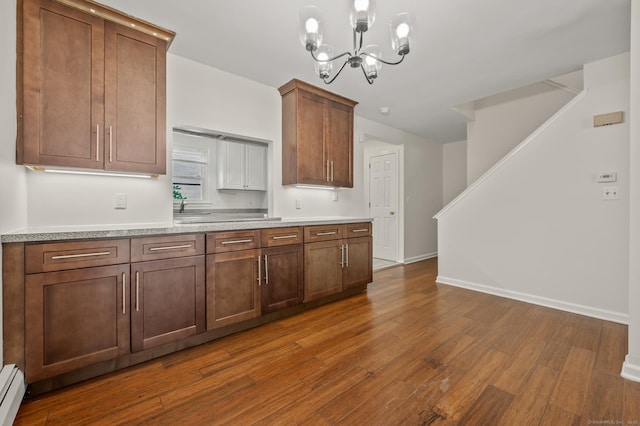 11 Danforth Ln Unit 11, Rocky Hill, CT 06067 - kitchen featuring dark wood finished floors, a chandelier, light countertops, a baseboard heating unit, and pendant lighting