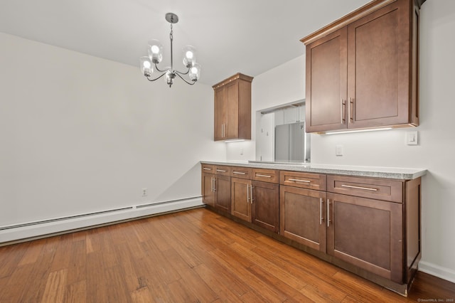 11 Danforth Ln Unit 11, Rocky Hill, CT 06067 - kitchen with a chandelier, a baseboard radiator, light countertops, wood finished floors, and hanging light fixtures