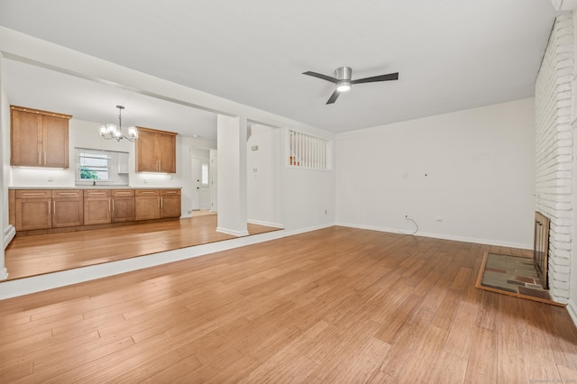 11 Danforth Ln Unit 11, Rocky Hill, CT 06067 - unfurnished living room featuring a chandelier, light wood finished floors, a ceiling fan, and a brick fireplace