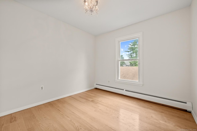 11 Danforth Ln Unit 11, Rocky Hill, CT 06067 - spare room featuring a baseboard radiator, wood finished floors, and a chandelier