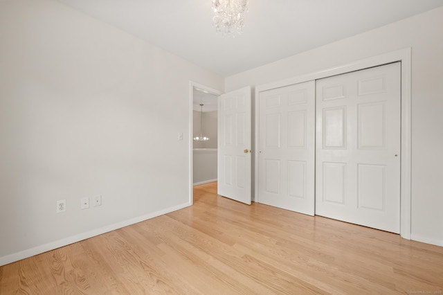 11 Danforth Ln Unit 11, Rocky Hill, CT 06067 - unfurnished bedroom featuring a chandelier, light wood finished floors, and a closet