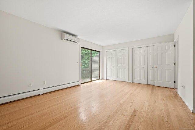 11 Danforth Ln Unit 11, Rocky Hill, CT 06067 - unfurnished bedroom featuring an AC wall unit, multiple closets, access to exterior, wood finished floors, and a baseboard radiator