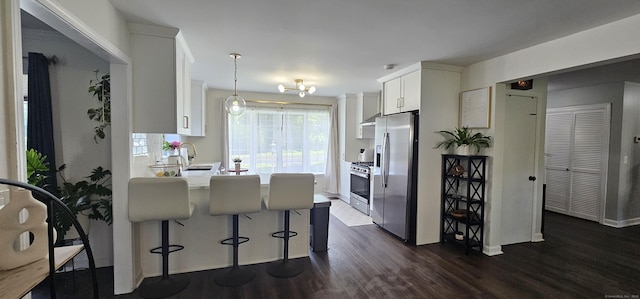 187 Two Rod Hwy, Wethersfield, CT 06109 - kitchen with appliances with stainless steel finishes, dark wood-type flooring, white cabinets, a peninsula, and a breakfast bar area
