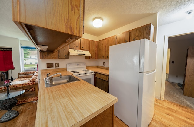 226 Laurel St Apt 4, East Haven, CT 06512 - kitchen featuring white appliances, under cabinet range hood, light countertops, light wood-type flooring, and a textured ceiling