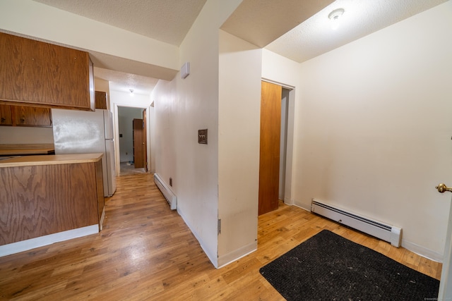 226 Laurel St Apt 4, East Haven, CT 06512 - kitchen with a baseboard radiator, freestanding refrigerator, brown cabinetry, and light wood-style floors