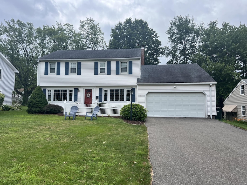 49 Holly Dr, Wethersfield, CT 06111 - colonial home with asphalt driveway, a chimney, a front lawn, a garage, and a porch