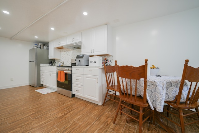 72 Harral Ave, Bridgeport, CT 06604 - kitchen with stainless steel appliances, light wood-type flooring, tasteful backsplash, recessed lighting, and white cabinetry