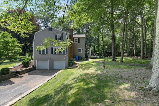 330 Foxwood Rd, Guilford, CT 06437 - view of front of property with asphalt driveway, a garage, a gambrel roof, a chimney, and a front lawn