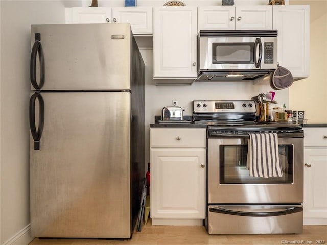 124 Court St Unit 8, New Haven, CT 06511 - kitchen with stainless steel appliances, dark countertops, light wood-style flooring, and white cabinets