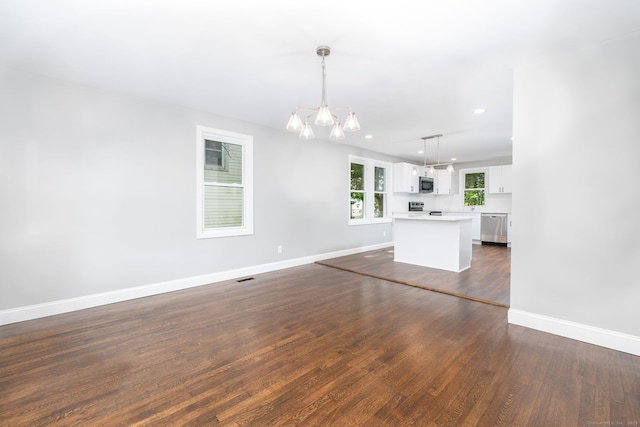 21 Whittlesey Ave, Waterbury, CT 06706 - unfurnished living room with a chandelier, dark wood-type flooring, and recessed lighting