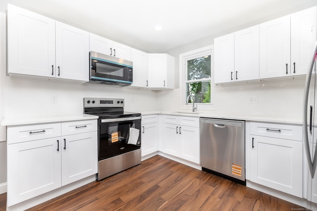 21 Whittlesey Ave, Waterbury, CT 06706 - kitchen featuring stainless steel appliances, dark wood-style floors, light countertops, white cabinetry, and backsplash