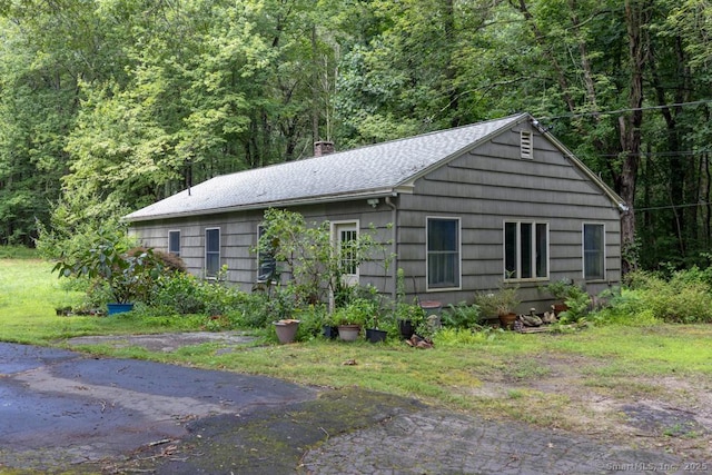76 Bushy Hill Rd, Deep River, CT 06417 - view of property exterior with a chimney, a view of trees, and a shingled roof