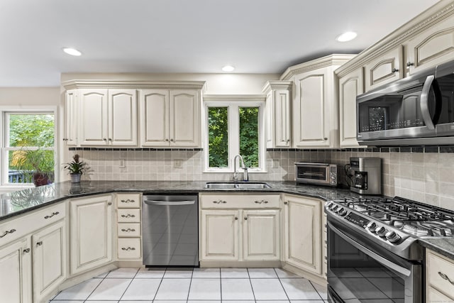 4 Quail Run Dr, Danbury, CT 06811 - kitchen with stainless steel appliances, tasteful backsplash, cream cabinetry, dark stone countertops, and recessed lighting
