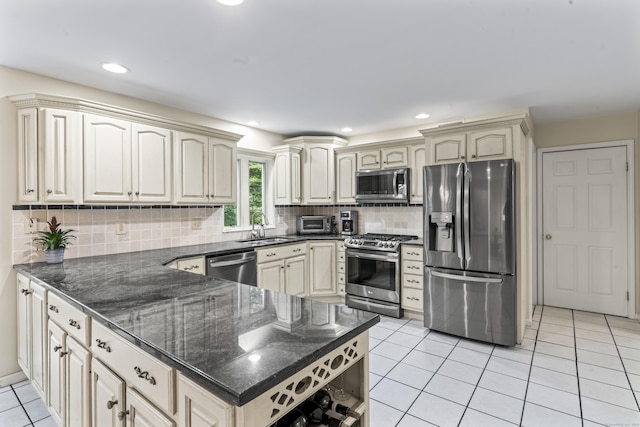4 Quail Run Dr, Danbury, CT 06811 - kitchen featuring appliances with stainless steel finishes, cream cabinets, a peninsula, light tile patterned floors, and recessed lighting