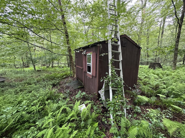 view of shed with a view of trees