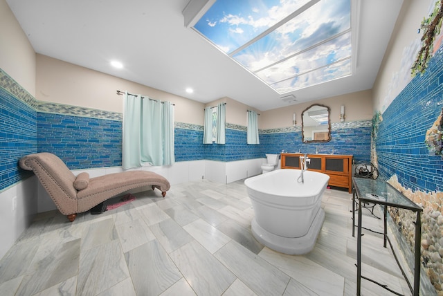 35 Flax Mill Ter, Milford, CT 06461 - bathroom with tile walls, a soaking tub, and wainscoting
