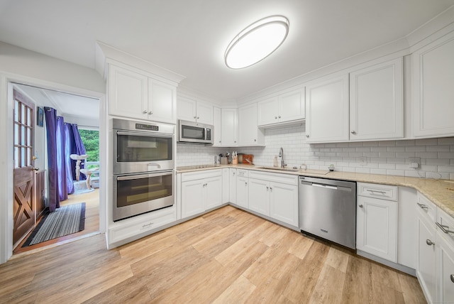 35 Flax Mill Ter, Milford, CT 06461 - kitchen featuring appliances with stainless steel finishes, light wood-style flooring, tasteful backsplash, and white cabinets