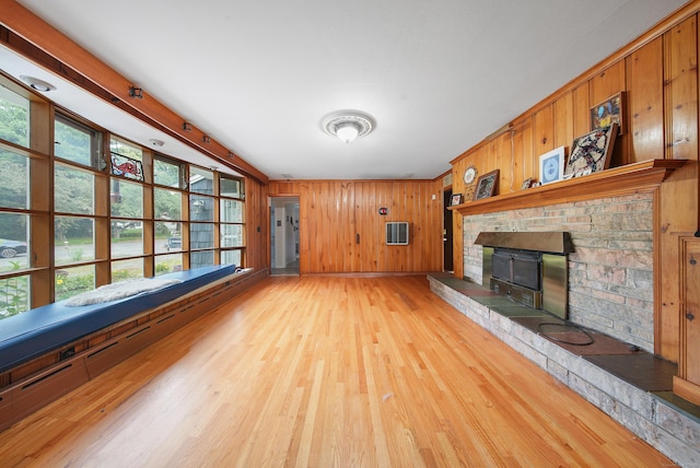 35 Flax Mill Ter, Milford, CT 06461 - unfurnished living room featuring plenty of natural light, light wood-style flooring, a fireplace, and wooden walls