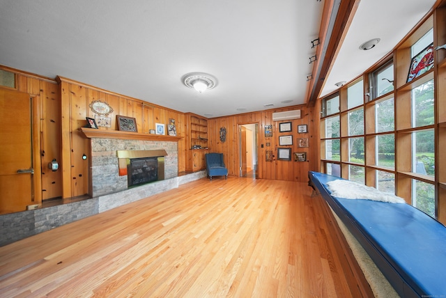 35 Flax Mill Ter, Milford, CT 06461 - unfurnished living room featuring wooden walls, a wall mounted AC, wood finished floors, a fireplace, and ornamental molding