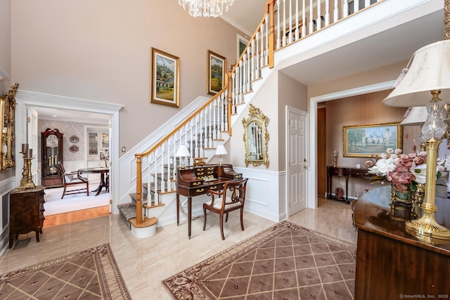 90 Soundview Ave, Shelton, CT 06484 - entryway with a towering ceiling, stairway, a decorative wall, a chandelier, and a wainscoted wall
