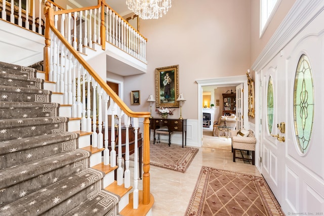 90 Soundview Ave, Shelton, CT 06484 - entryway with a high ceiling, stairway, a chandelier, a decorative wall, and wainscoting