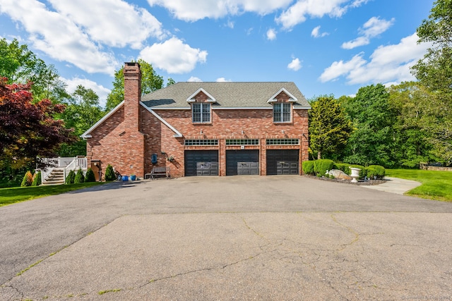 90 Soundview Ave, Shelton, CT 06484 - view of front of property featuring driveway, an attached garage, brick siding, a chimney, and stairway