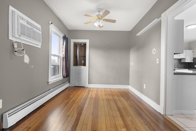1691 State St, Hamden, CT 06517 - empty room featuring a baseboard heating unit, light wood finished floors, ceiling fan, and a wall mounted AC