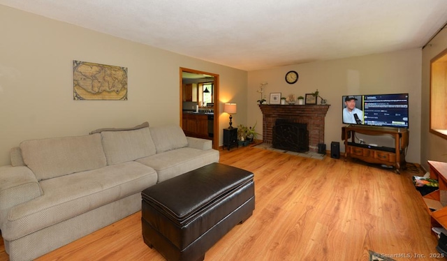 215 White Birch Dr, Southbury, CT 06488 - living room featuring light wood-style floors and a brick fireplace