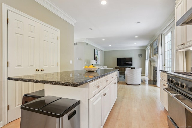 61 Brookview Ct, Groton, CT 06340 - kitchen featuring high end stainless steel range, a fireplace, wall chimney range hood, crown molding, and light wood-style floors