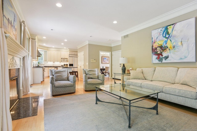 61 Brookview Ct, Groton, CT 06340 - living room featuring light wood-style floors, crown molding, a premium fireplace, and recessed lighting