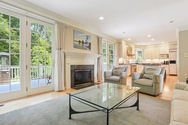 61 Brookview Ct, Groton, CT 06340 - living area featuring ornamental molding, healthy amount of natural light, light wood-style floors, a premium fireplace, and recessed lighting