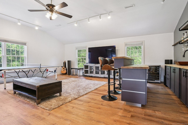 61 Brookview Ct, Groton, CT 06340 - living area featuring track lighting, wine cooler, vaulted ceiling, and healthy amount of natural light