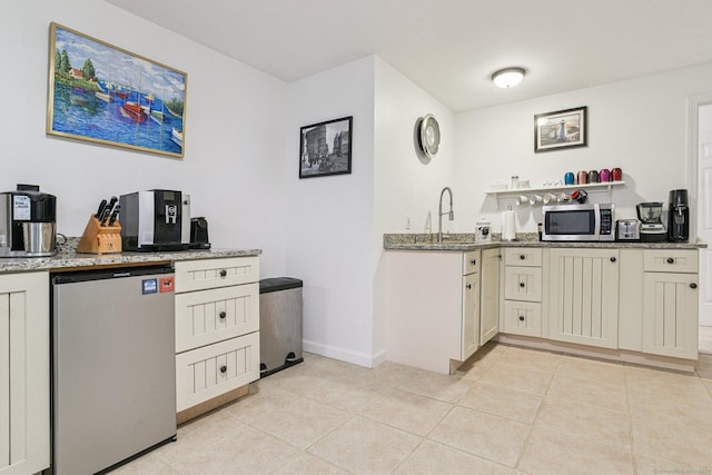 61 Brookview Ct, Groton, CT 06340 - kitchen with stainless steel microwave, refrigerator, light stone counters, and light tile patterned floors