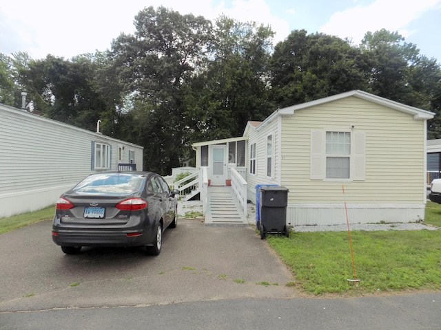 61 Elm St, East Windsor, CT 06088 - manufactured / mobile home featuring a front lawn and view of scattered trees