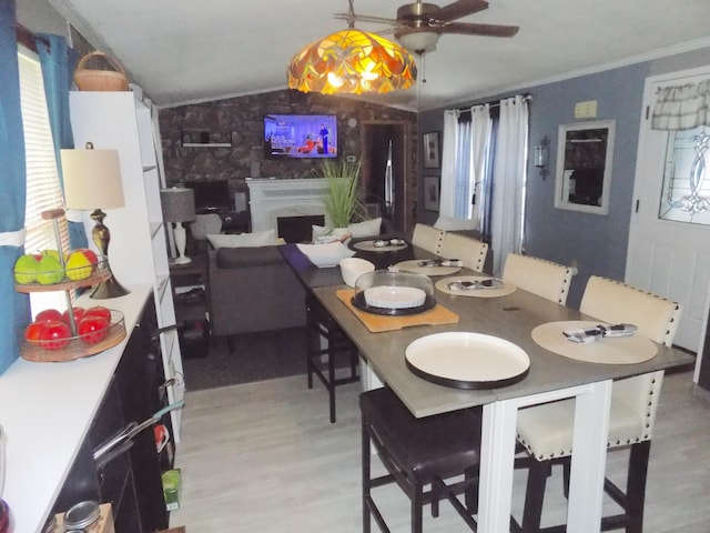 61 Elm St, East Windsor, CT 06088 - dining room with light wood-style flooring, lofted ceiling, ceiling fan, a premium fireplace, and ornamental molding