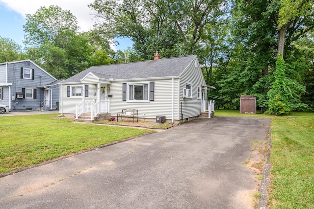76 Landers Rd, East Hartford, CT 06118 - view of front facade featuring a chimney, a shingled roof, a front yard, and asphalt driveway